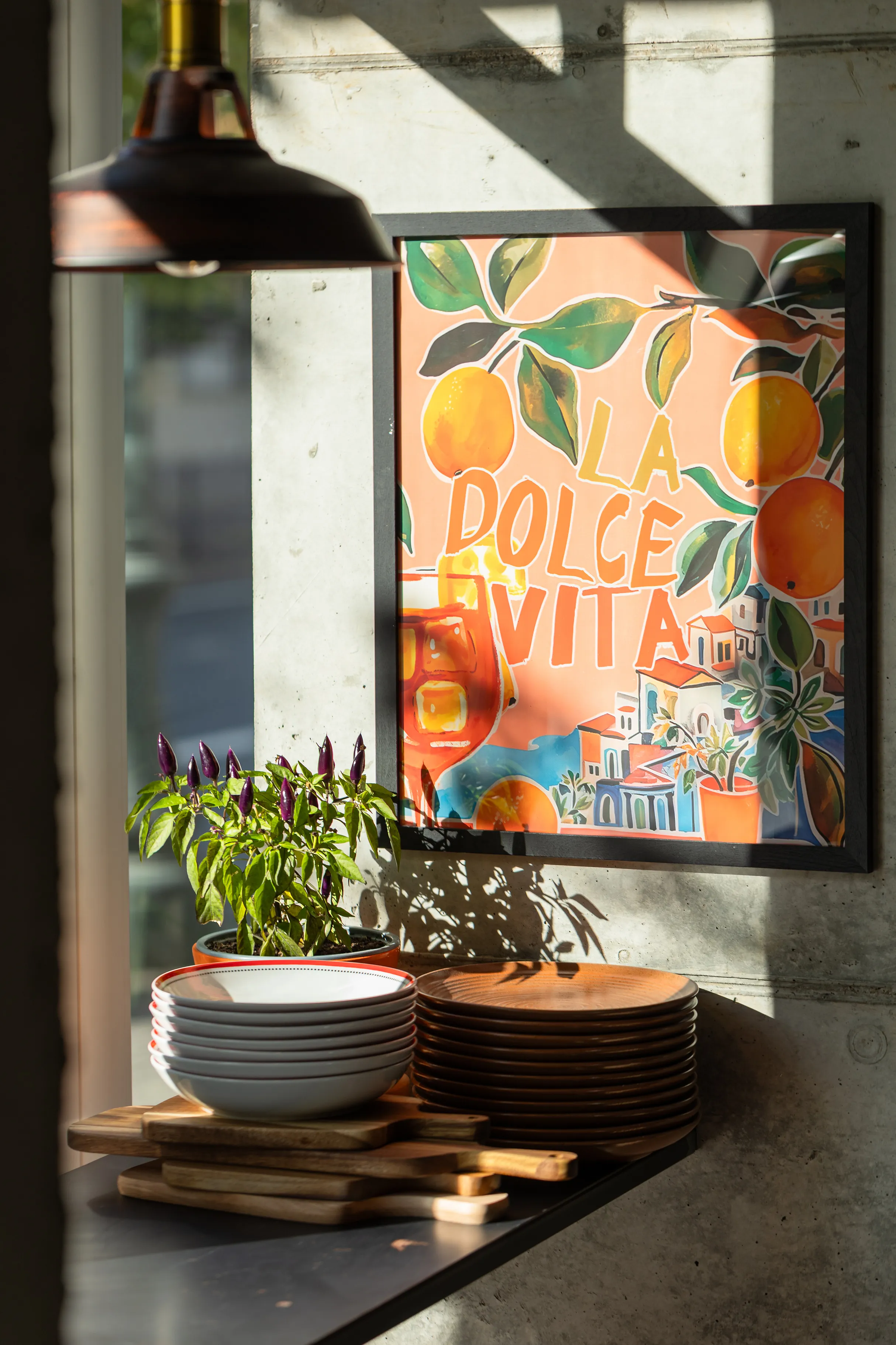 Restorano interjeras su lėkščių stirta ir „La Dolce Vita“ plakatu