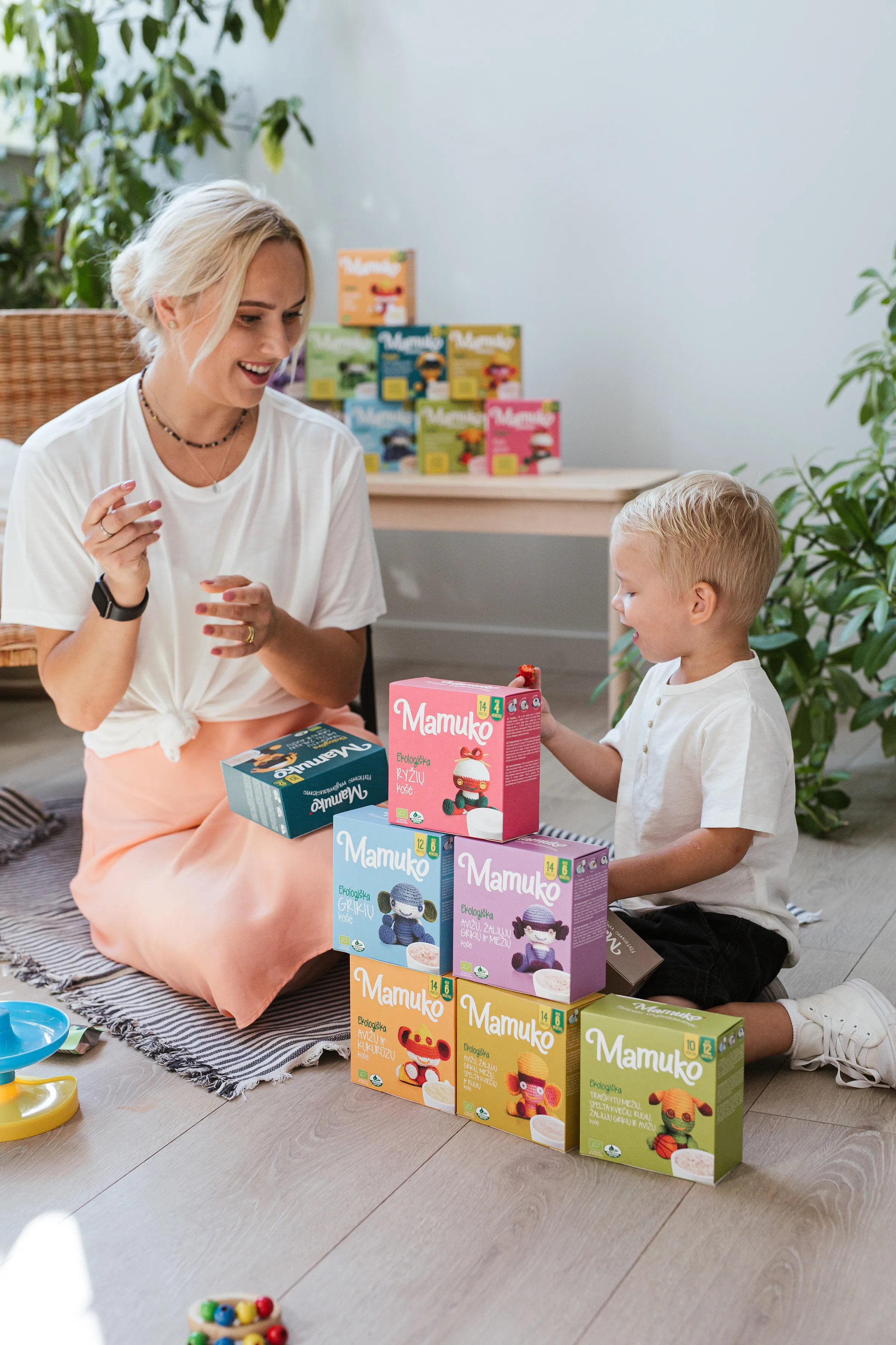 Mama su vaiku žaidžia su vaikiškų sausainių pakuotėmis