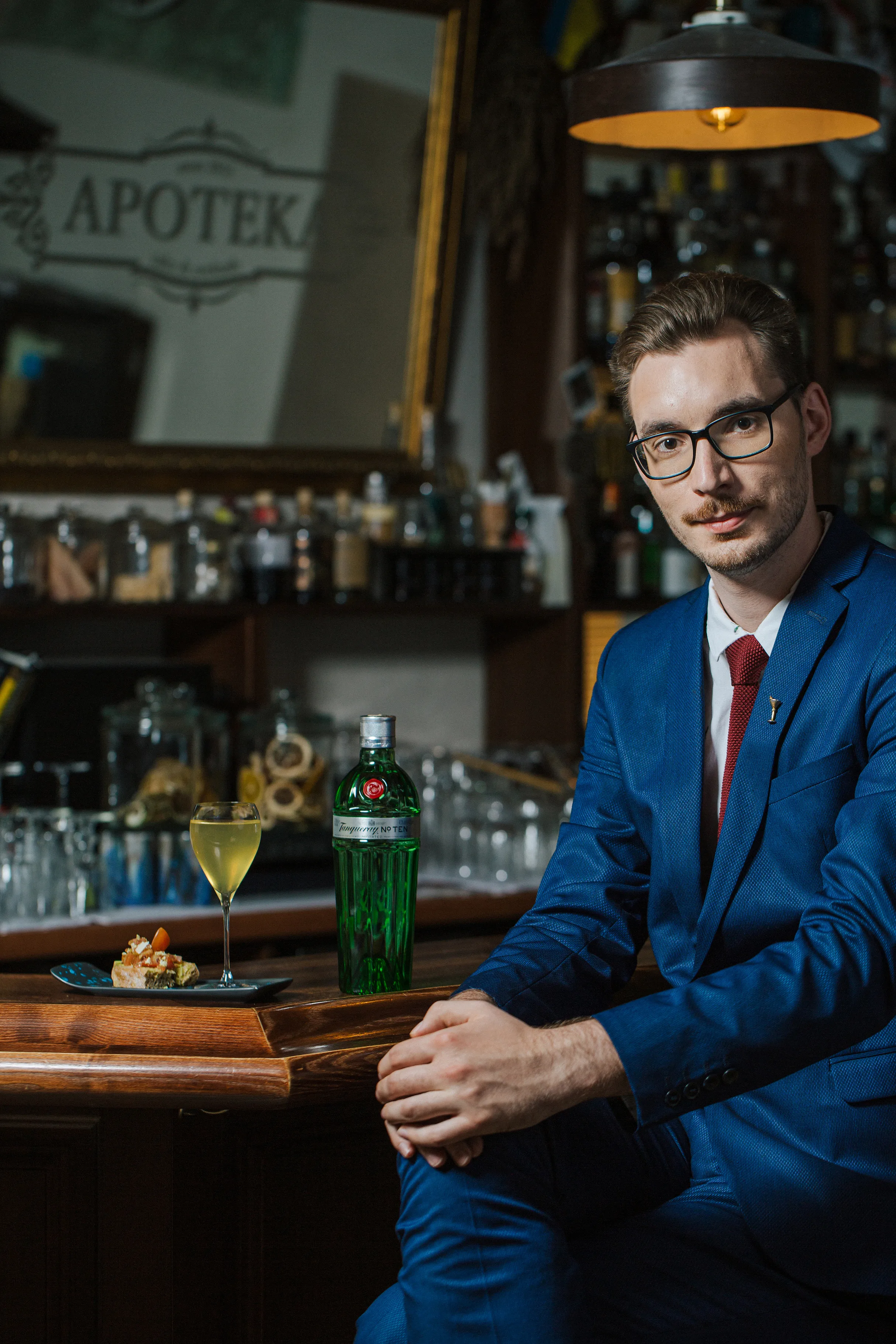 Vyras kostiumu sėdi prie baro