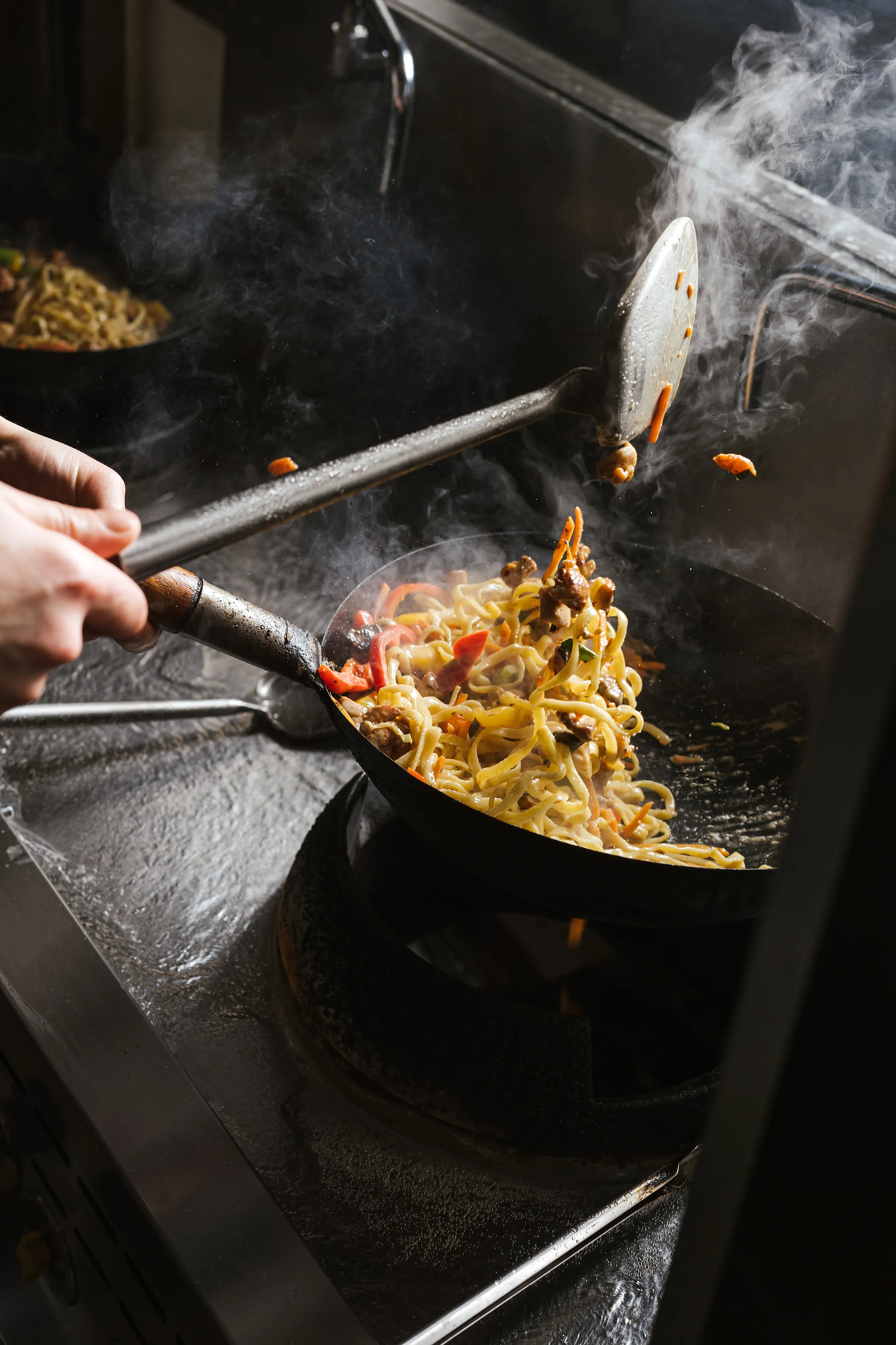 Makaronai maišomi garuojančioje wok keptuvėje